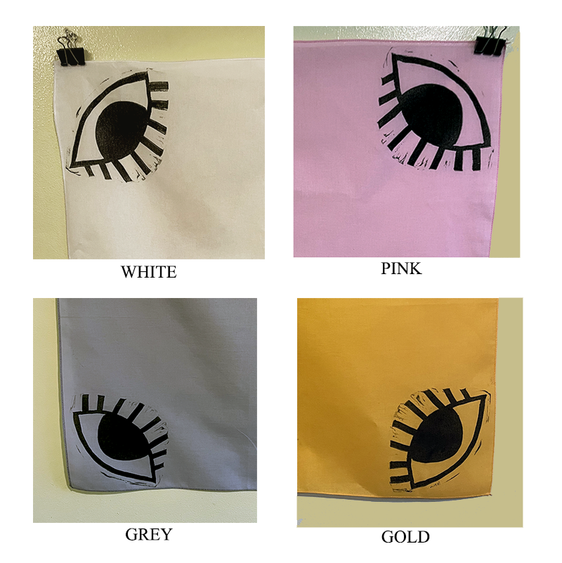 Hand printed bandanas with eye designs in each corner. The eye design is in black ink on either pink, white, grey or gold bandanas.